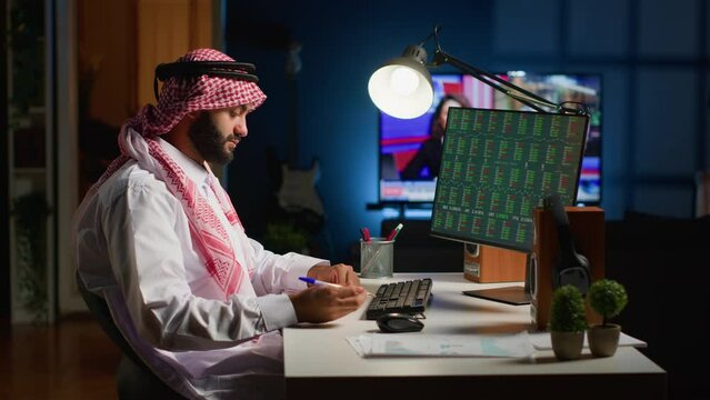 Professional arab broker investor checking stock exchange valuation, analyzing investment financial profit. Muslim stockholder looking at market shares graphs while working from home