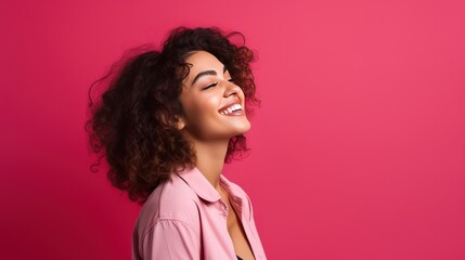Side view of an attractive hispanic woman feeling happy in front of a bright pink background - Powered by Adobe