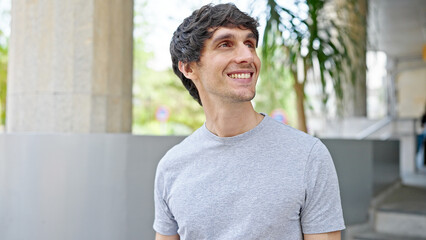 Obraz premium Young hispanic man smiling confident looking to the side at street