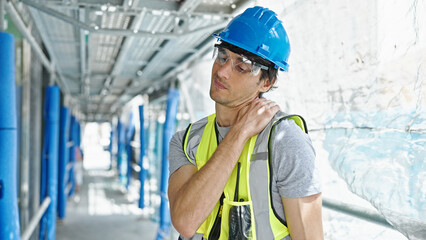 Young hispanic man architect suffering for cervical pain at construction place