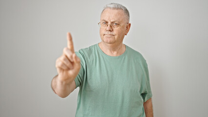 Middle age grey-haired man standing with serious expression saying no with finger over isolated...