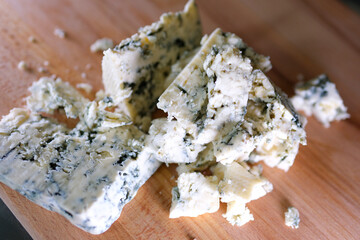 Rotation cheese on black slate plate. Delicious cheese Dorblu on the cutting board on background. High quality 4k footage