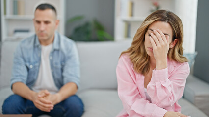 Man and woman couple sitting on sofa arguing at home