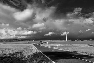 On the road with cloudy sky above with black and white color theme 