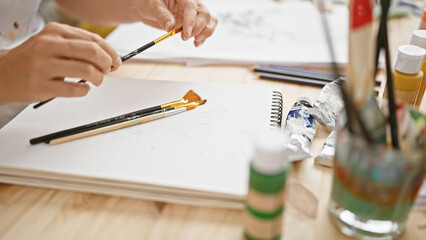 Art studio insight, artist's hands deftly cleaning paintbrushes, embracing passion at a cozy...