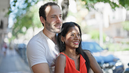Obraz premium Beautiful couple smiling confident hugging each other at street