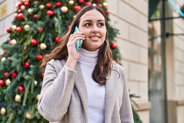 Young beautiful hispanic woman smiling confident talking on the smartphone at street