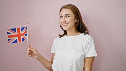 Young woman smiling confident holding united kingdom flag over isolated pink background