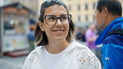 Beautiful young hispanic woman smiling confident looking to the side in the streets of Stockholm