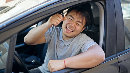  smiling confident holding key of new car at street