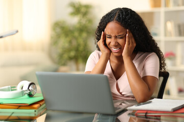 Black student suffering migraine studying at home - obrazy, fototapety, plakaty