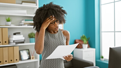 African american woman business worker reading document at the office - obrazy, fototapety, plakaty