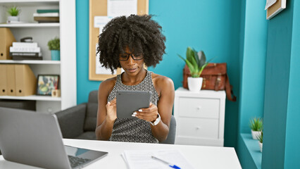 African american woman business worker using touchpad and laptop at the office