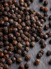 black pepper seeds on the surface of a black stone