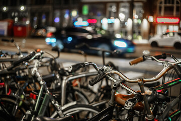 Bicycle parking in the city street of Amsterdam at night. Traditional Dutch urban transport