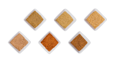 Various Indian Spices in Small White Bowls on white background