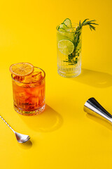 Cocktail Negroni and mojito cocktail on yellow background