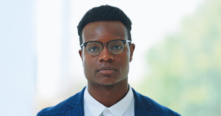 Portrait, glasses and serious with business black man in an office for corporate of professional work. Face, mission and mindset with a young employee in a workplace for growth or company development