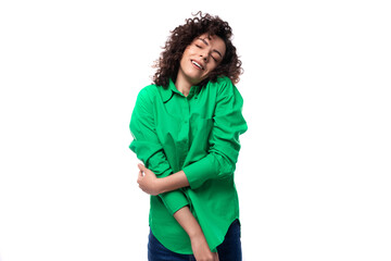 Charming slender young employee of the company woman with black hair is dressed in a green shirt is...