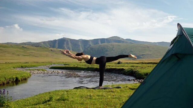 Tranquil woman performs yoga pose and practice exercise for body wellness at mountain views. Healthy sport lifestyle and calm relaxation at scenic landscape
