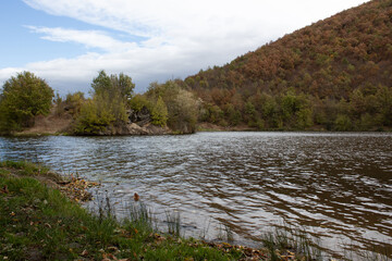 Autumn on the lake. Beautiful landscape of forest over the lake. Cloudy sky over autumn lake