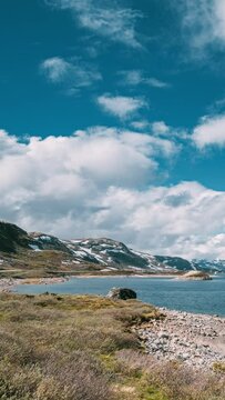 Oppland, Tyin Lake, Norway. Vertical Footage Video. Stones On Coast Of Beautiful Lake Tyin In Summer Day. Norwegian Nature.