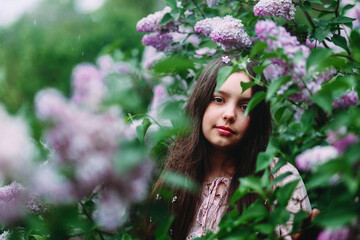 Girl smiles in the garden in summer. lilac