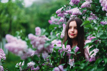 Girl smiles in the garden in summer. lilac