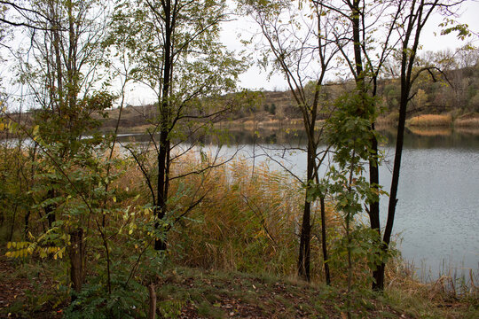 Yellow and green leaves on the trees around the lake. Autumn time in nature. Cristal clean tourquise wather.