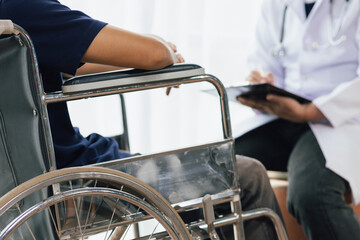 Patient with knee pain and unable to walk in a wheelchair sees a doctor in the hospital for...