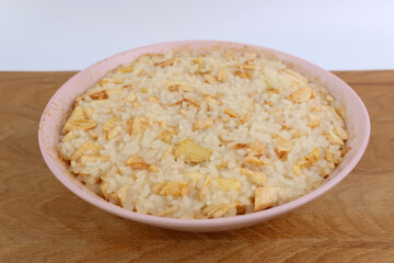 Rice porridge with apples in a bowl close-up.