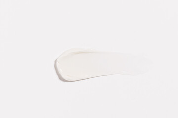 texture close-up of a smear of white cream on a white isolated background. moisturizing and nourishing the skin of the face and body