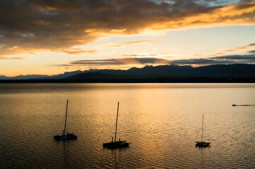 sunset over the Leman lake (Geneva lake) with sailboats and the Alps in the background - 677697021