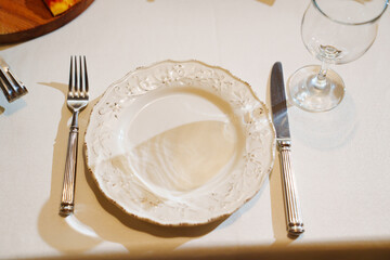 Top view. White plate in retro style with cutlery and glass.