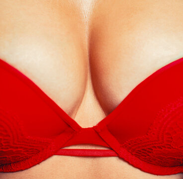 Sexy female boob in red bra. Sexy boob. Close up of breast of girl presenting her bra. Woman with natural sexy boobs in lingerie. Sexy young woman in red lingerie