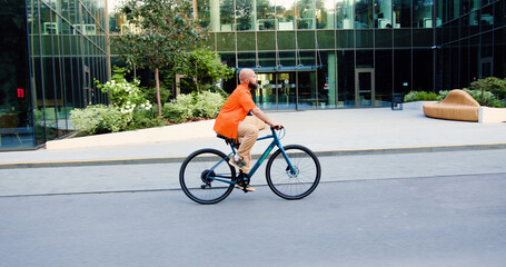 Cyclist man riding fixed gear sport bike in sunny day on a city. Urban city traveler concept. Attractive manager personal assistant cycling commuting to work by eco-friendly vehicle. Modern healthy