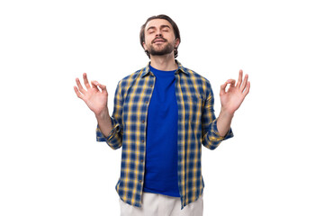portrait of a pleasant calm young european brunette with a beard dressed stylishly in a shirt