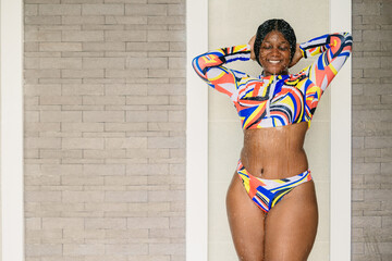 African black plus size woman enjoy refreshing splashing water at swimming pool shower happy smiling. - obrazy, fototapety, plakaty