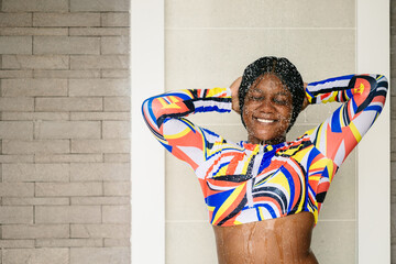 African black plus size woman enjoy refreshing splashing water at swimming pool shower happy...