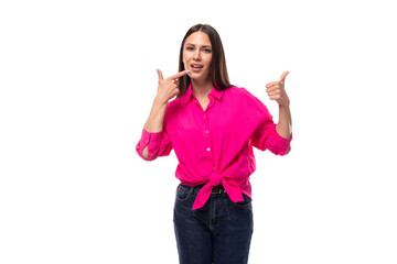 Obraz na płótnie Canvas pretty young brunette businesswoman dressed in a pink shirt gesturing with her hands on a white background with copy space