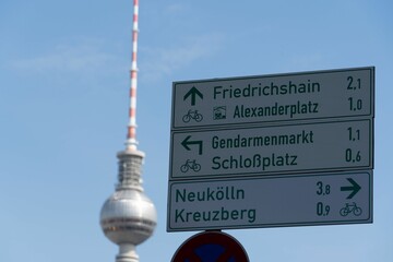 Closeup shot of a street sign showing directions to Alexanderplatz, Schlobplaz, and Kreuxberg - obrazy, fototapety, plakaty