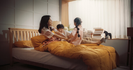 Happy Korean Family in the Morning: Active and Playful Child Running to her Parents' Bedroom to Wake Them Up. Excited Girl Forcing her Parents Out of Bed to Have a Fun Weekend Together