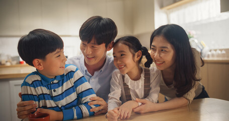 Portrait of Happy Korean Family Looking at Camera and Smiling in their Sunny Apartment. Young Parents and Two Adorable Kids Posing for a Photo, Keeping Memories, Showing Love and Support