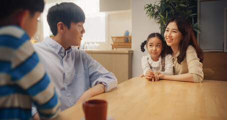 Portrait of Happy Small Korean Family Talking Together in Their Sunny Home. Parents Communicating,...