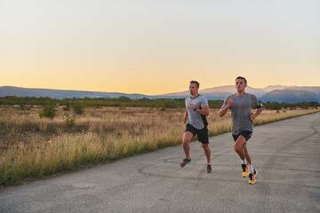 Obraz premium Group of handsome men running together in the early morning glow of the sunrise, embodying the essence of fitness, vitality, and the invigorating joy of embracing nature's tranquility during their