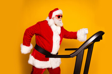 Profile side photo of sporty retired man wear santa claus costume training gym cardio regime warmup isolated on yellow color background