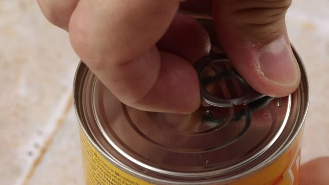 ouverture d'une boite de conserve par son anneau	