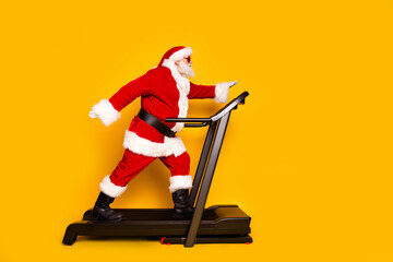 Full length profile photo of overweight santa walk training treadmill empty space christmas offer...