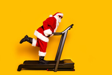 Full length profile photo of charismatic grandfather santa workout treadmill empty space christmas...