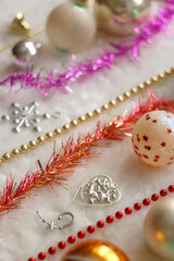 Colorful vintage Christmas ornaments and white faux fur blanket. Cute and kitschy Christmas decorations. Selective focus.